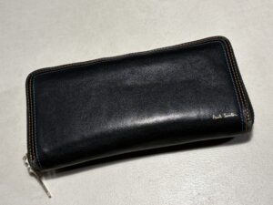 黒のレザー(革)製ポールスミスのジップアラウンド(ラウンドファスナー)長財布。外側に小さなロゴ刻印があり、ファスナー周りのステッチがマルチカラー(またはコントラストカラー)になっているデザイン。
