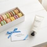 ホワイトデーのお返しに喜ばれるマカロンとハンドクリームのギフト。メッセージカードが添えられた明るい雰囲気。