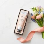 ホワイトデーのギフトとして贈られる、高級感のあるハンドクリームとおしゃれな花束のセット。