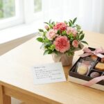 母の日のプレゼントに喜ばれる、上品なアレンジメントフラワーと高級焼き菓子の詰め合わせ。